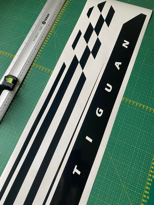 A vinyl decal with a geometric pattern and the word 'TIGUAN' displayed on a surface, likely a car part.