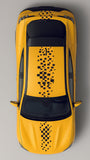 Top view of a yellow taxi with black roof and pixelated design on a gray background