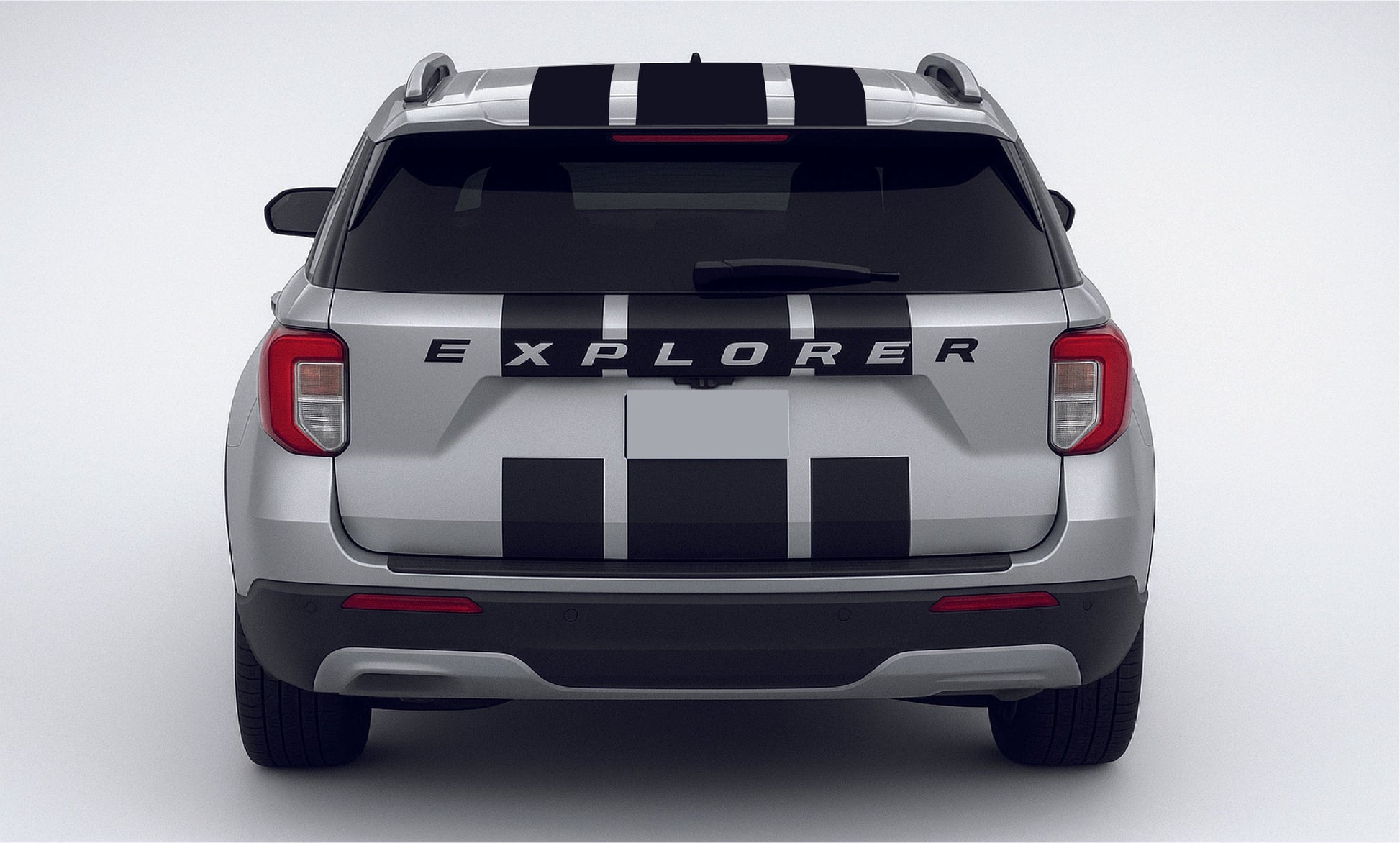 Back view of a silver Ford Explorer with black and white stripes on a white background
