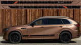 Bronze-colored SUV with 'CX-80' branding against a wooden background