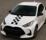 White car with black and white checkered design on a tiled floor