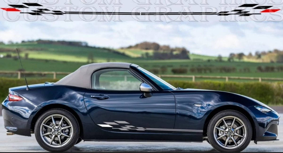 A dark blue Mazda MX-5 Miata convertible with a black soft top, shown in profile against a blurred countryside background. A checkered flag graphic and the text 'CUSTOM GRAPHICS' are overlaid at the top.