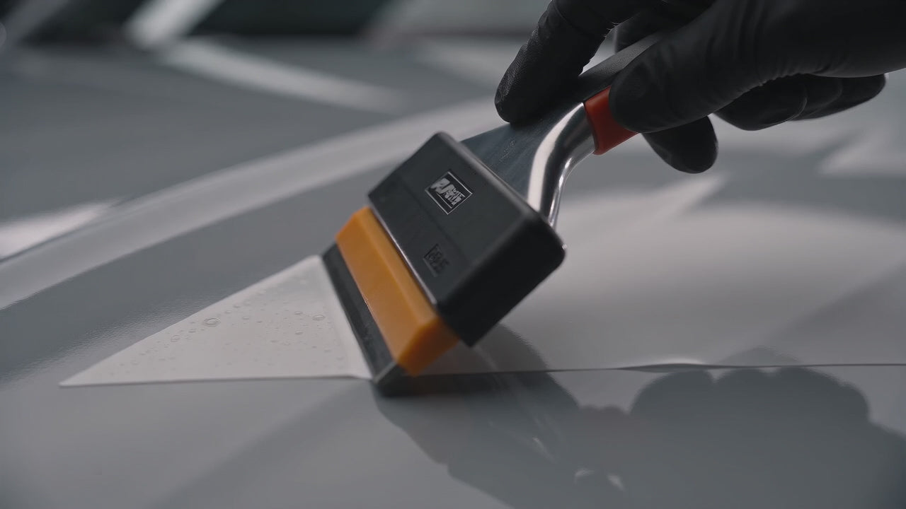 Load video: Brothers Graphics automotive vinyl decals shown in close-up during application, followed by customized vehicles in a dark studio.